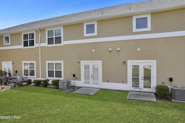 back of house featuring french doors, stucco siding, and a lawn