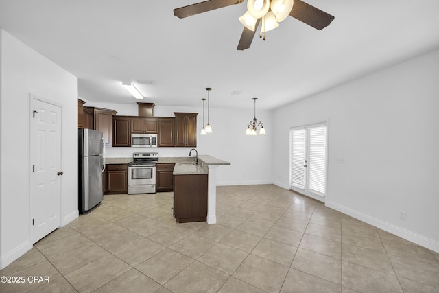 kitchen with dark brown cabinetry, a sink, light tile patterned floors, ceiling fan with notable chandelier, and stainless steel appliances