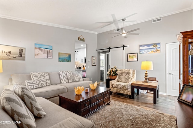 17462 Front Beach Rd Unit 24C, Panama City Beach, FL 32413 - living area with a barn door, crown molding, wood finished floors, and ceiling fan
