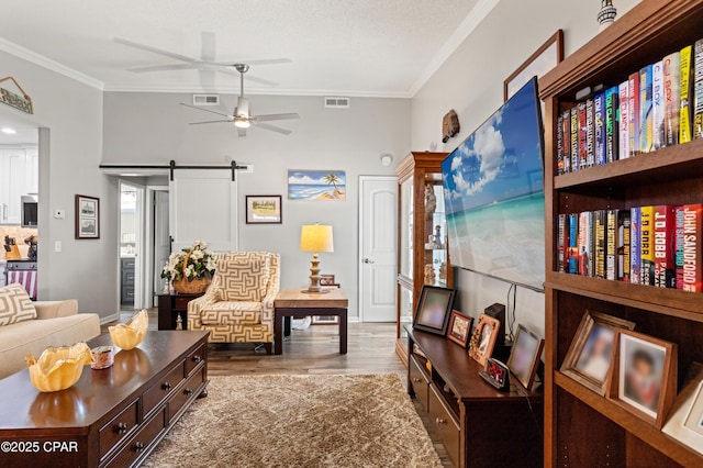 17462 Front Beach Rd Unit 24C, Panama City Beach, FL 32413 - living area featuring a barn door, crown molding, ceiling fan, and wood finished floors