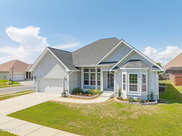 view of front of home with roof with shingles, fence, an attached garage, a front lawn, and concrete driveway