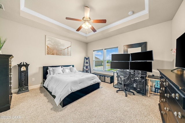 bedroom featuring crown molding, baseboards, a tray ceiling, a ceiling fan, and carpet