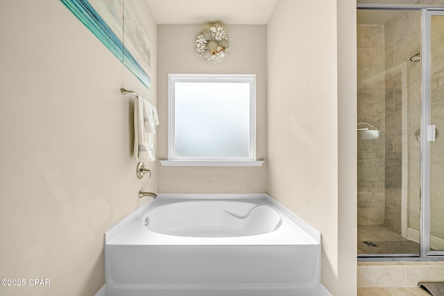 bathroom with a stall shower and a garden tub