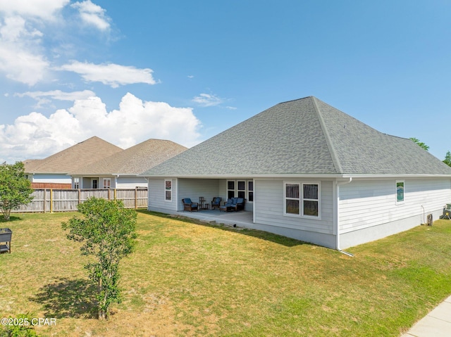 back of property with a patio, a lawn, fence, and roof with shingles