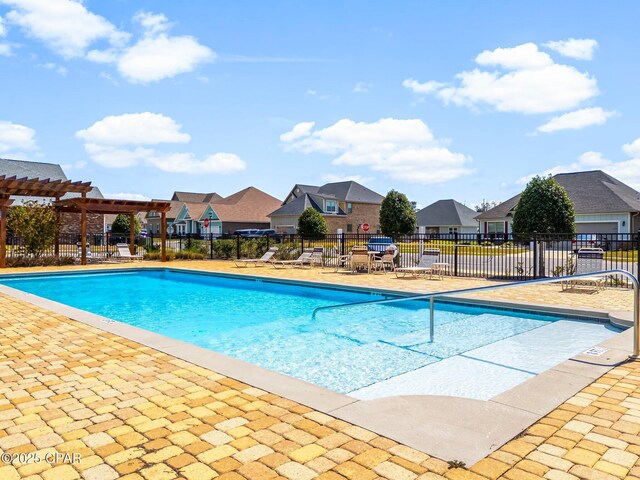 community pool featuring a pergola, fence, a residential view, and a patio