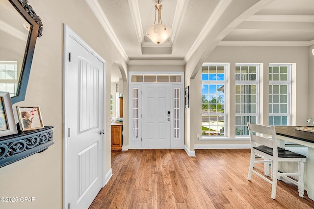 entryway featuring crown molding, arched walkways, a wealth of natural light, and light wood finished floors