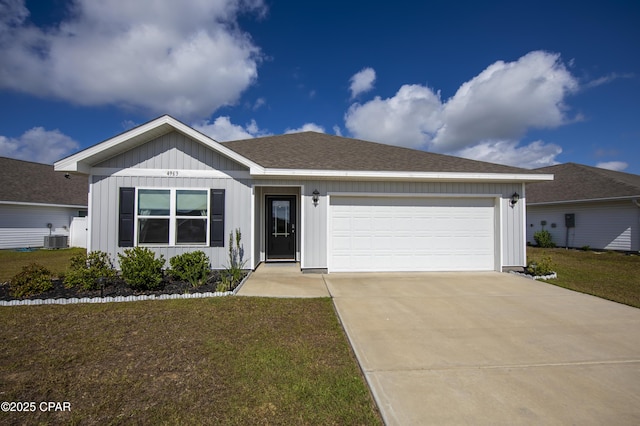 ranch-style house with a front lawn, central AC unit, board and batten siding, concrete driveway, and an attached garage
