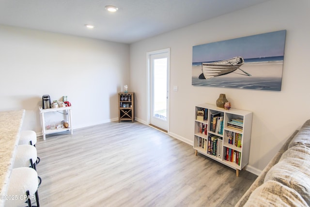 living area featuring baseboards, recessed lighting, and wood finished floors