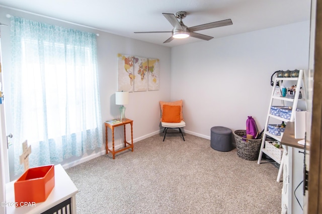 living area featuring carpet floors, a ceiling fan, and baseboards
