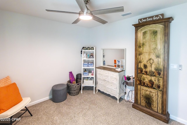 interior space with light colored carpet, a ceiling fan, visible vents, and baseboards