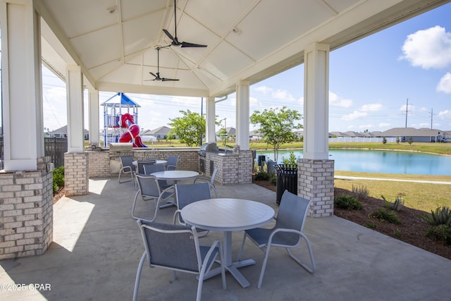 view of patio with outdoor dining space, a gazebo, an outdoor kitchen, a water view, and a ceiling fan