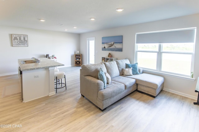 living area with recessed lighting, baseboards, and light wood finished floors