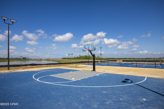 view of basketball court featuring a water view, fence, and community basketball court