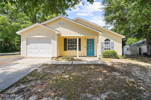 view of front of home featuring covered porch, a garage, a shed, and driveway