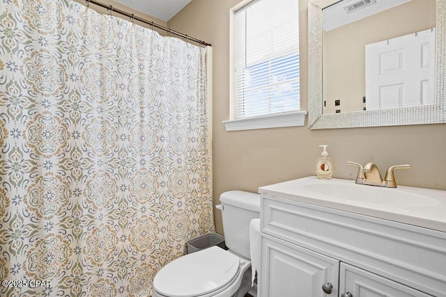 bathroom featuring curtained shower, vanity, toilet, and visible vents