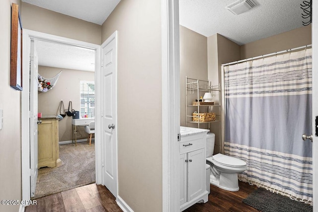 full bathroom with a textured ceiling, visible vents, wood finished floors, and toilet