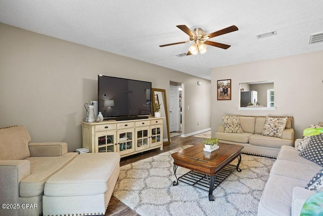 living room featuring visible vents, wood finished floors, and ceiling fan