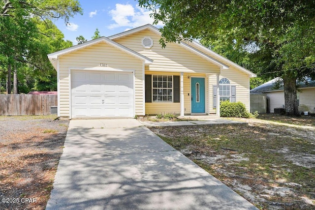 view of front facade with driveway, an attached garage, and fence