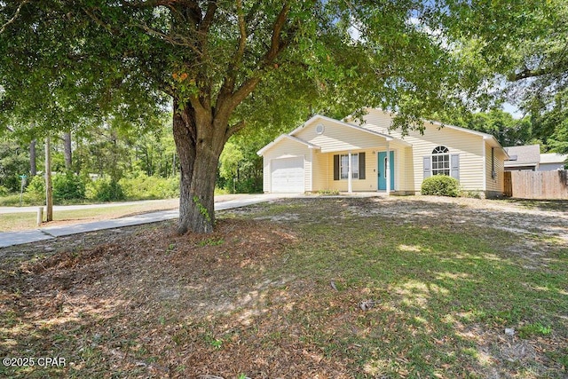 view of front of property with fence, a garage, and driveway