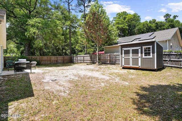 view of yard with a patio area, an outbuilding, a fenced backyard, and a storage unit