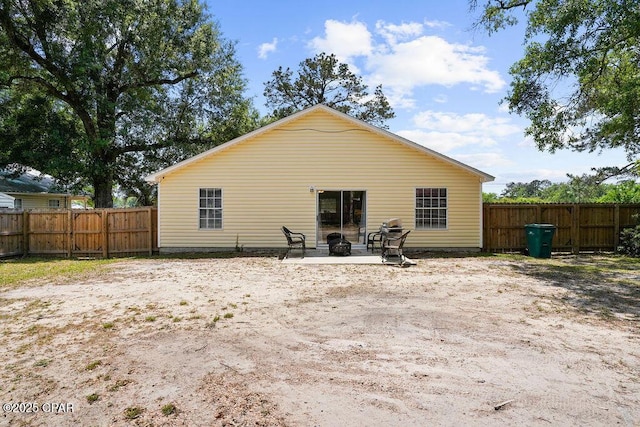 rear view of house featuring an outdoor fire pit, a patio area, and a fenced backyard