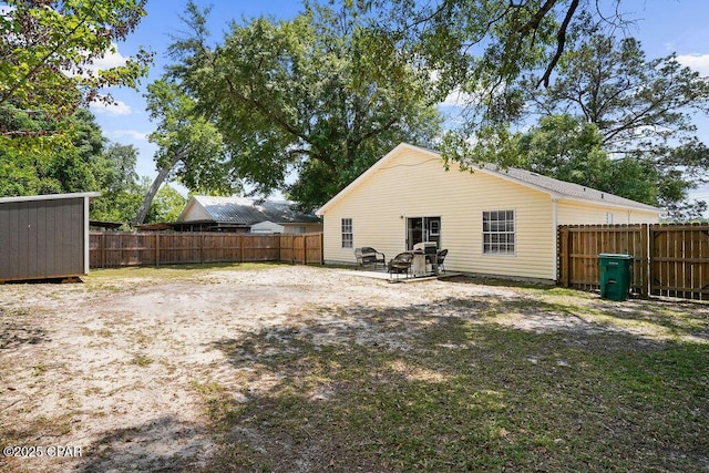 back of property with a fenced backyard and an outbuilding