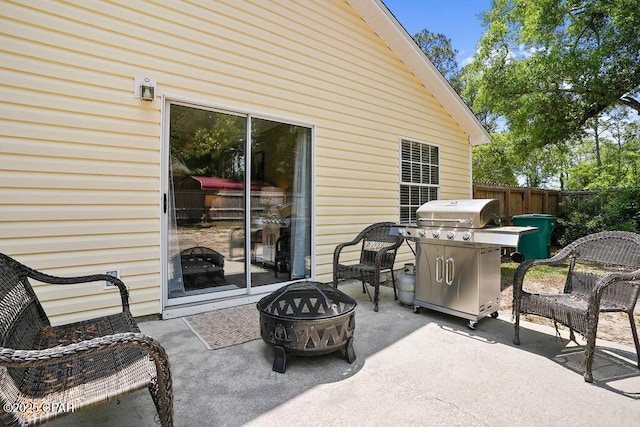 view of patio / terrace featuring a fire pit, grilling area, and fence
