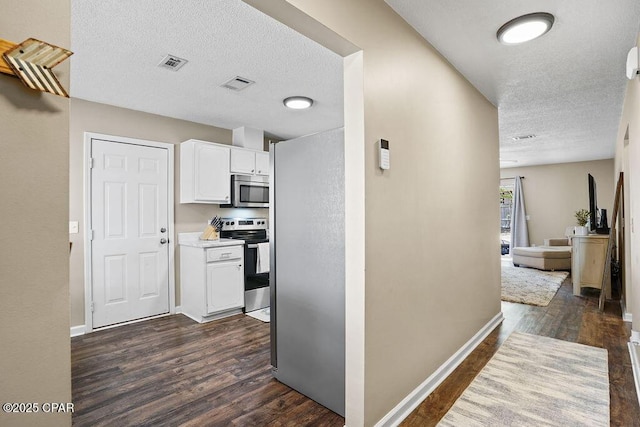 hall featuring dark wood-style flooring, a textured ceiling, baseboards, and visible vents