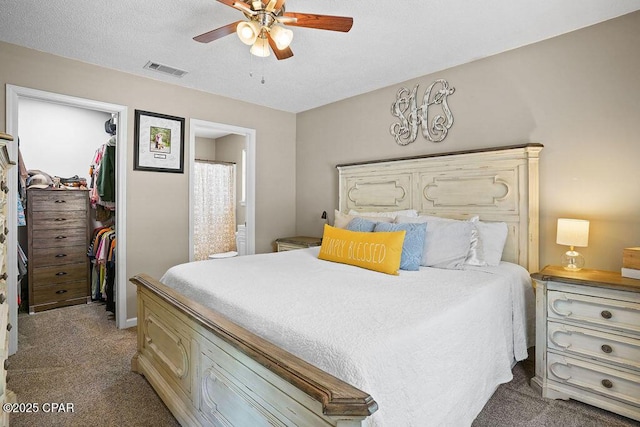 bedroom with a ceiling fan, a closet, visible vents, light colored carpet, and a spacious closet