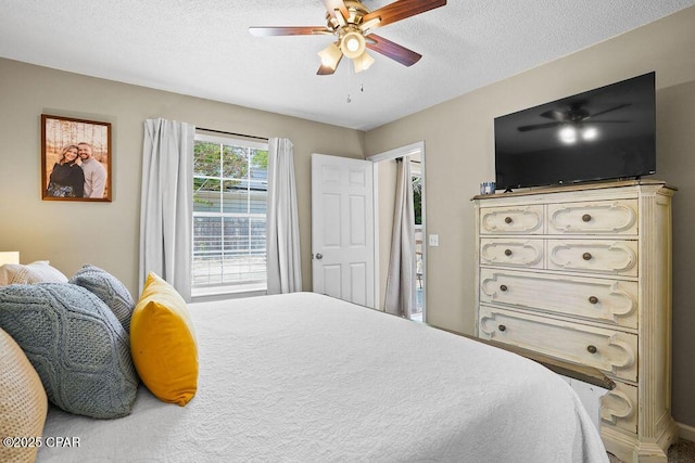 bedroom with a ceiling fan and a textured ceiling
