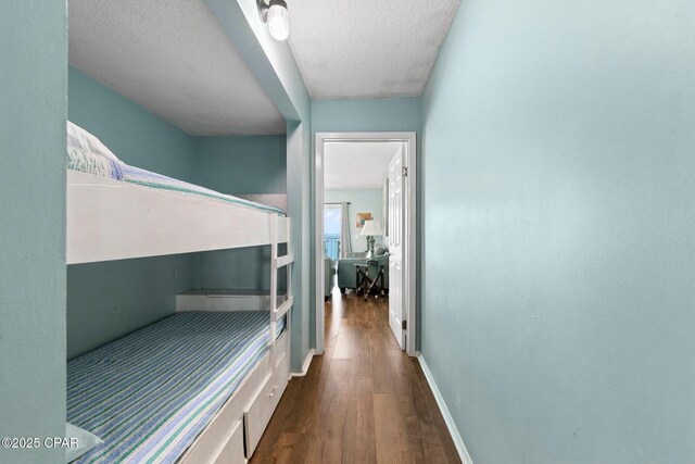 8743 Thomas Dr Unit 809, Panama City Beach, FL 32408 - hall with wood finished floors, a textured ceiling, and baseboards