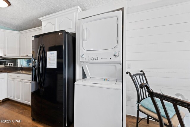 8743 Thomas Dr Unit 809, Panama City Beach, FL 32408 - washroom with estacked washer and dryer, a textured ceiling, and dark wood-style floors