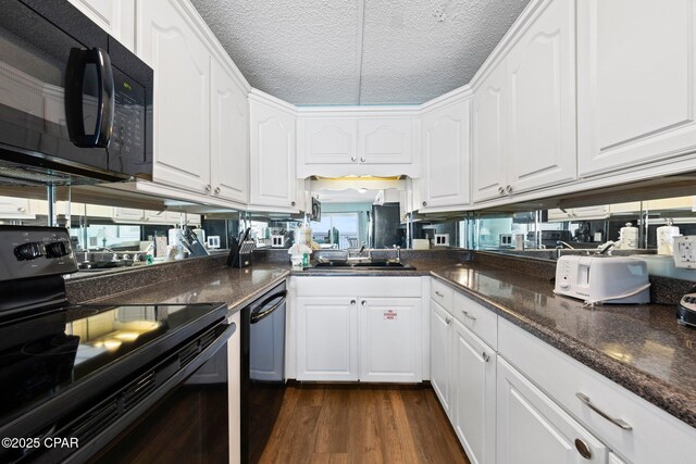 8743 Thomas Dr Unit 809, Panama City Beach, FL 32408 - kitchen featuring black appliances, a sink, white cabinets, dark wood-type flooring, and a textured ceiling
