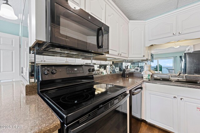 8743 Thomas Dr Unit 809, Panama City Beach, FL 32408 - kitchen with black appliances, white cabinets, a textured ceiling, dark wood-type flooring, and a sink