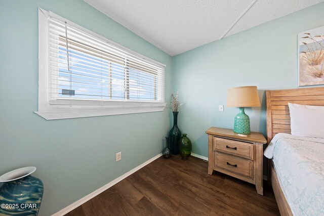 8743 Thomas Dr Unit 809, Panama City Beach, FL 32408 - bedroom with dark wood-style floors, baseboards, and a textured ceiling