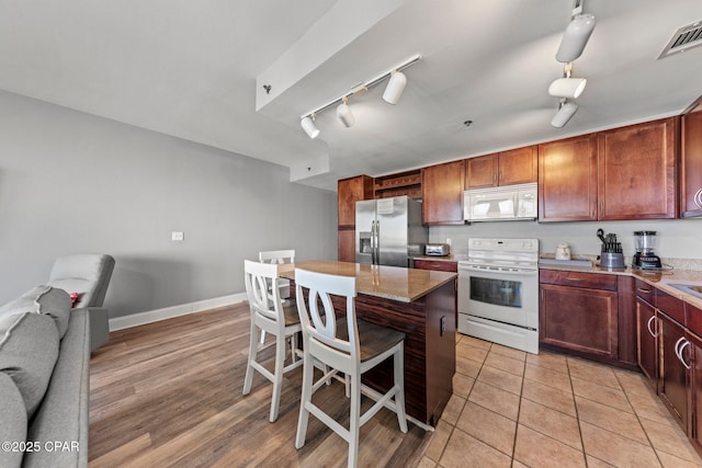 9860 S Thomas Dr Unit 1018, Panama City Beach, FL 32408 - kitchen featuring white appliances, a kitchen breakfast bar, rail lighting, a center island, and open floor plan