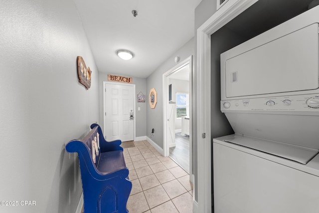 9860 S Thomas Dr Unit 1018, Panama City Beach, FL 32408 - laundry room featuring stacked washing machine and dryer, light tile patterned flooring, and baseboards