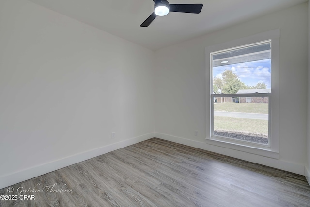 unfurnished room featuring baseboards, ceiling fan, and wood finished floors