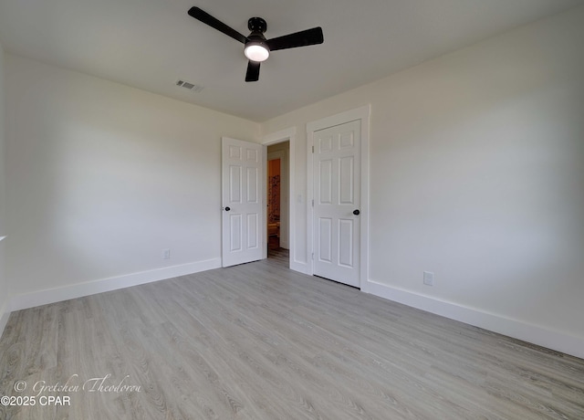 unfurnished bedroom with baseboards, ceiling fan, wood finished floors, and visible vents