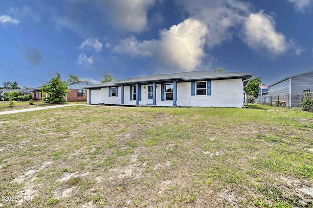 ranch-style house featuring brick siding, fence, and a front yard