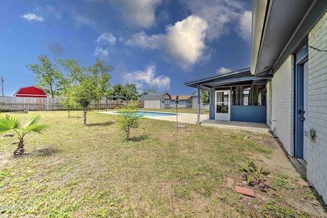 view of yard featuring a fenced in pool, a fenced backyard, a sunroom, and a patio area