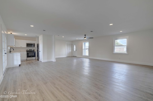 unfurnished living room featuring recessed lighting, baseboards, a ceiling fan, and light wood-style floors