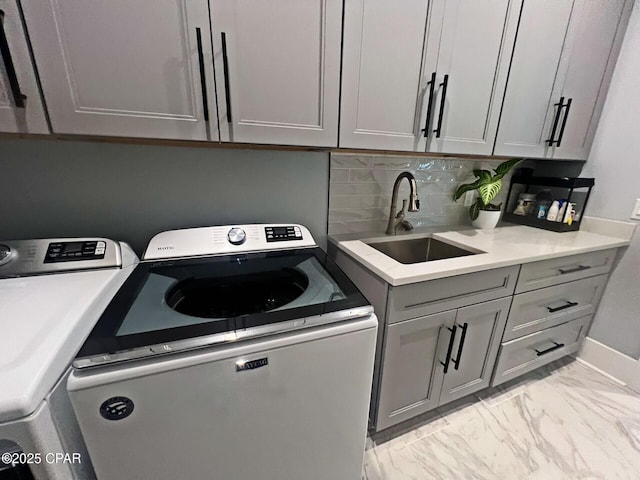 3639 Preserve Blvd, Panama City Beach, FL 32408 - laundry room featuring marble finish floor, washing machine and dryer, baseboards, a sink, and cabinet space