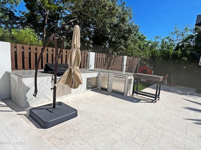 3639 Preserve Blvd, Panama City Beach, FL 32408 - view of patio with an outdoor kitchen and a fenced backyard
