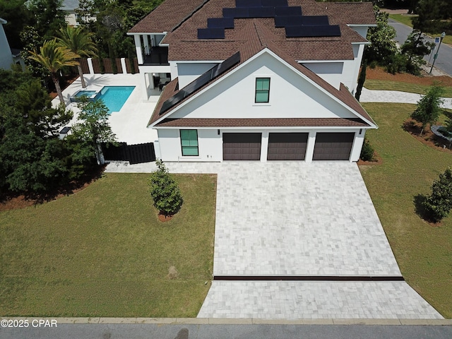 3639 Preserve Blvd, Panama City Beach, FL 32408 - view of front facade featuring fence, stucco siding, a front yard, solar panels, and decorative driveway