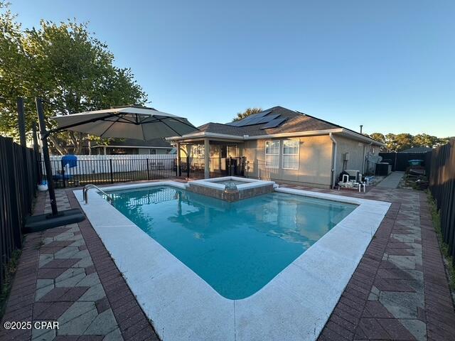 view of pool with a fenced backyard, a patio, and a pool with connected hot tub