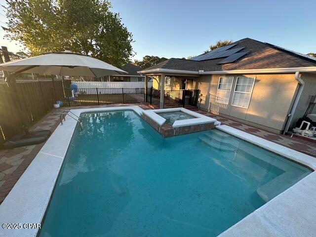 view of pool featuring a pool with connected hot tub and a fenced backyard