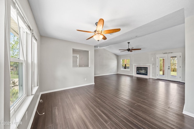 unfurnished living room with baseboards, a ceiling fan, dark wood-style floors, and lofted ceiling