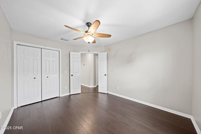 unfurnished bedroom featuring visible vents, baseboards, and dark wood-style flooring
