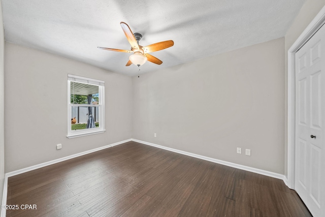 unfurnished bedroom with a closet, baseboards, and dark wood-type flooring